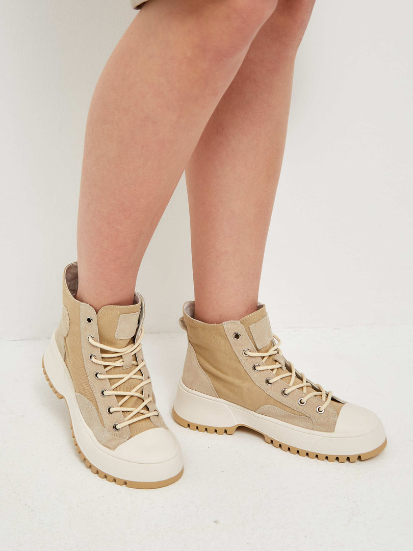 Stylish lace-up high top sneakers with textured accents for a trendy look.