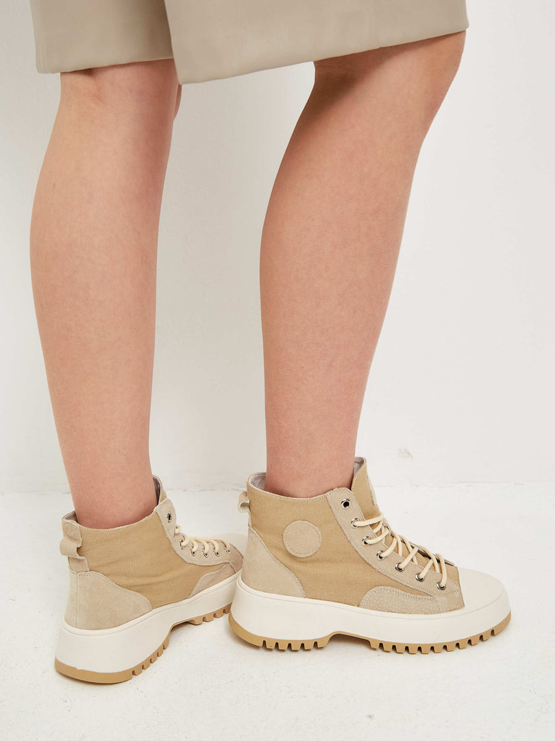 A stylish pair of lace-up high top sneakers with textured detailing, perfect for a trendy and casual look.