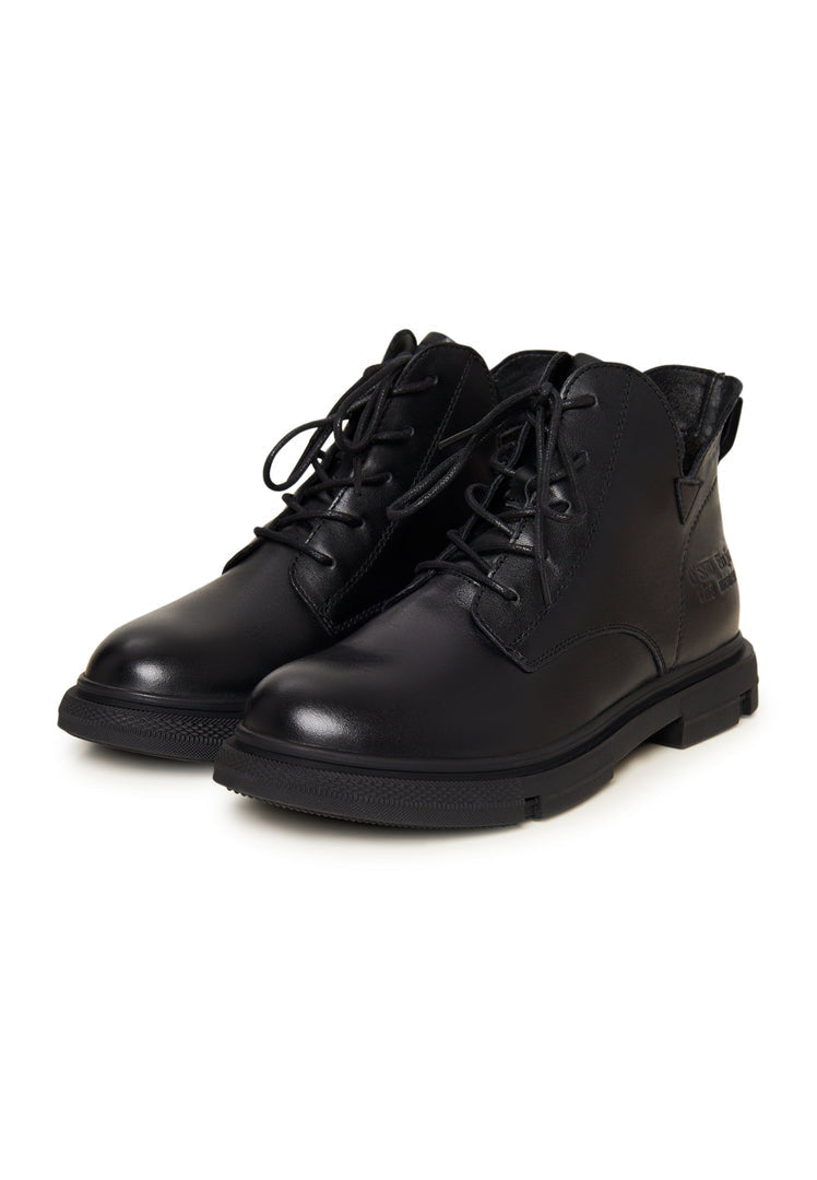 A stylish pair of black leather flat-sole ankle boots for women, featuring a sleek design with a flat heel.