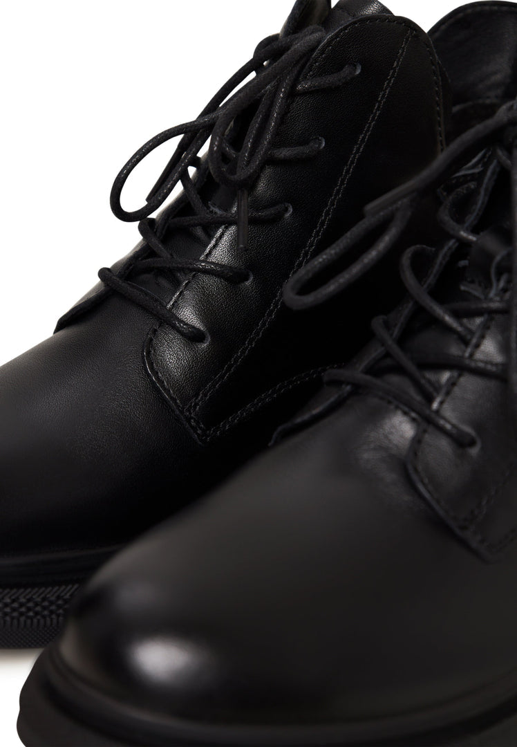 A stylish pair of black leather women's ankle boots with a flat sole and heel.