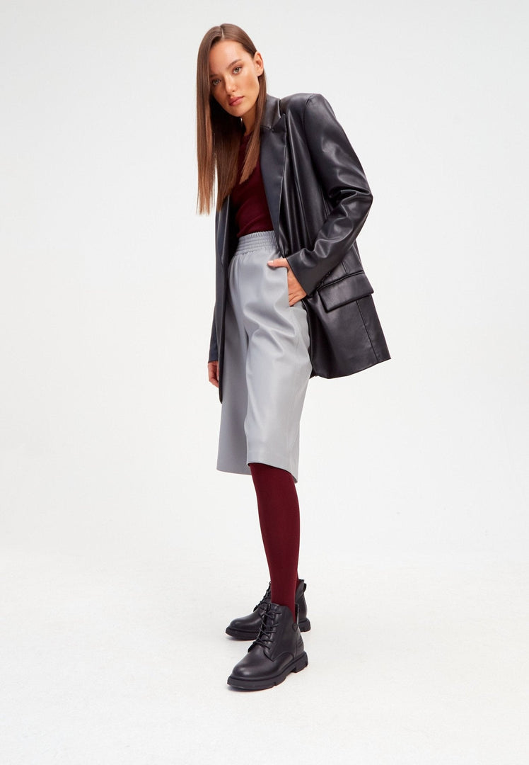 A trendy pair of black leather flat sole ankle boots for women, featuring a stylish flat heel design.