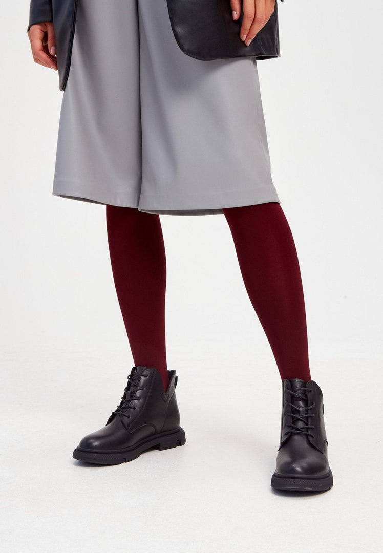 A pair of stylish black leather women's ankle boots with a flat sole and heel.