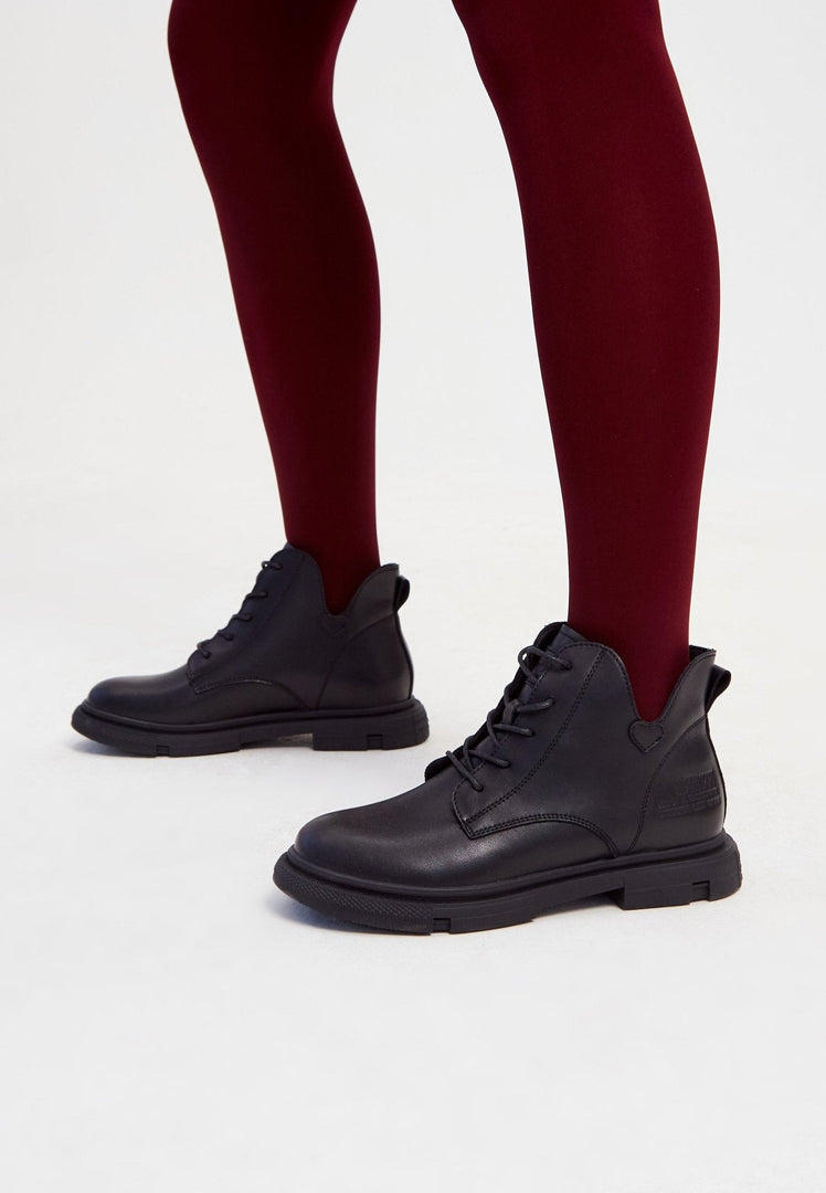 A stylish pair of women's black leather flat sole ankle boots with a chic and versatile design.