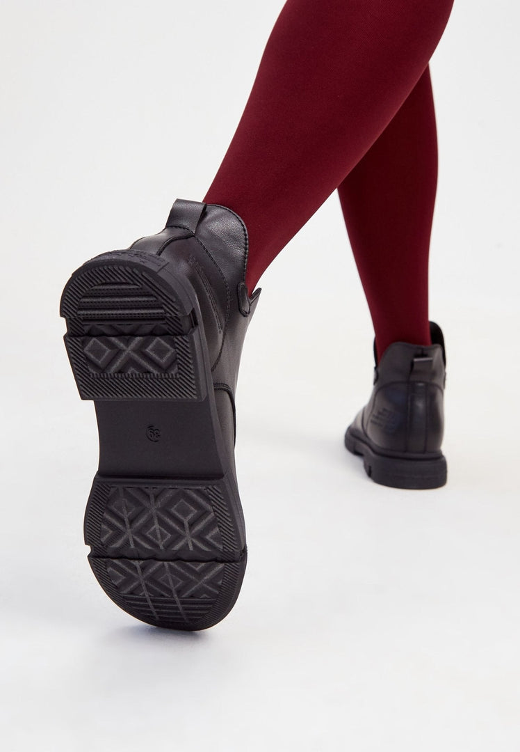 A stylish pair of black leather women's ankle boots with a flat sole and heel.