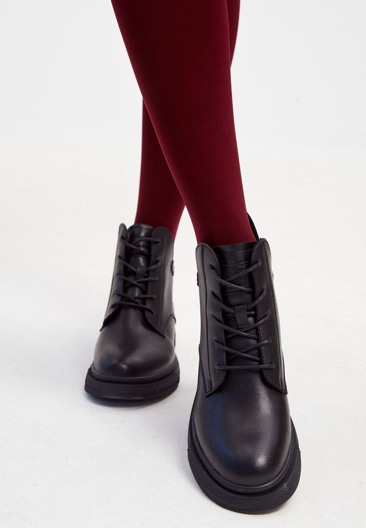 A stylish pair of women's black leather ankle boots with a flat sole and heel.