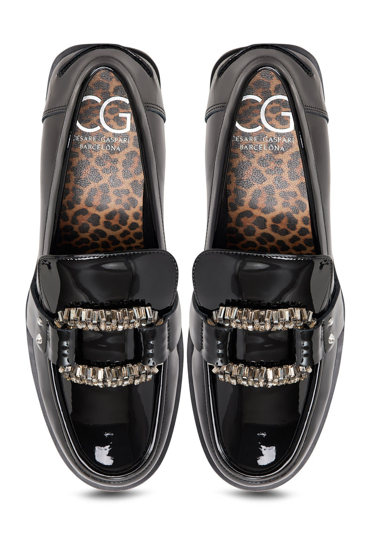 A close-up image of black patent loafers featuring crystal embellishments, also known as Bagheera loafers, making them the perfect black embellished shoes.