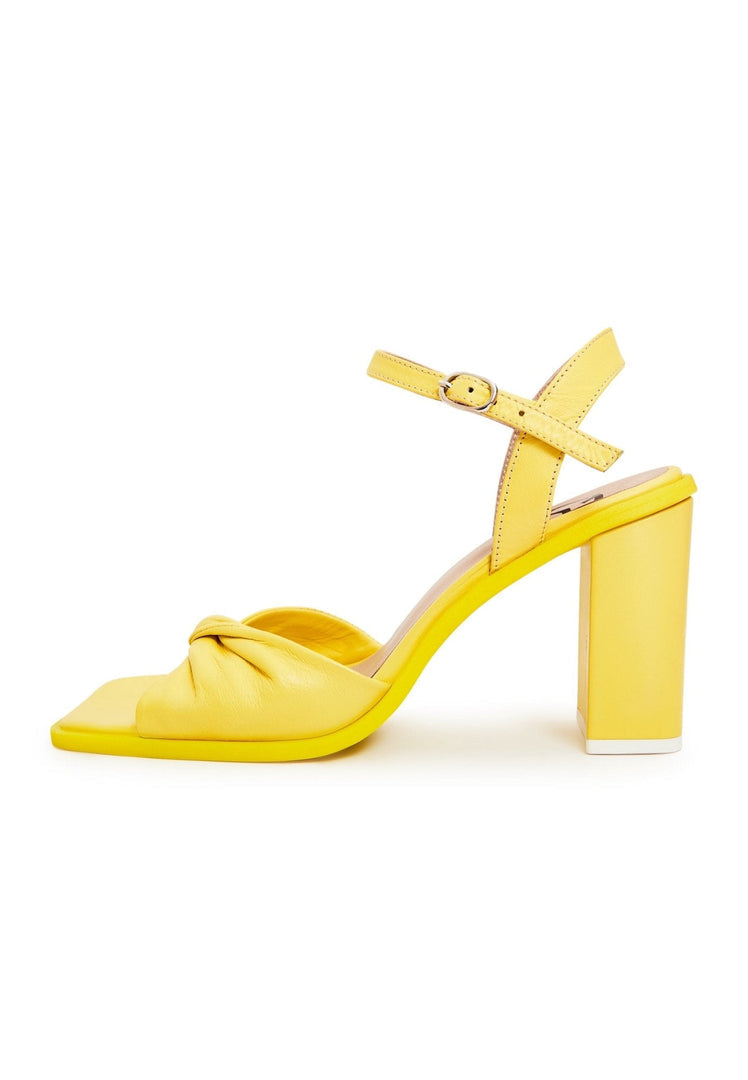 A stylish pair of yellow block heels, a timeless and fashionable choice for women's footwear.