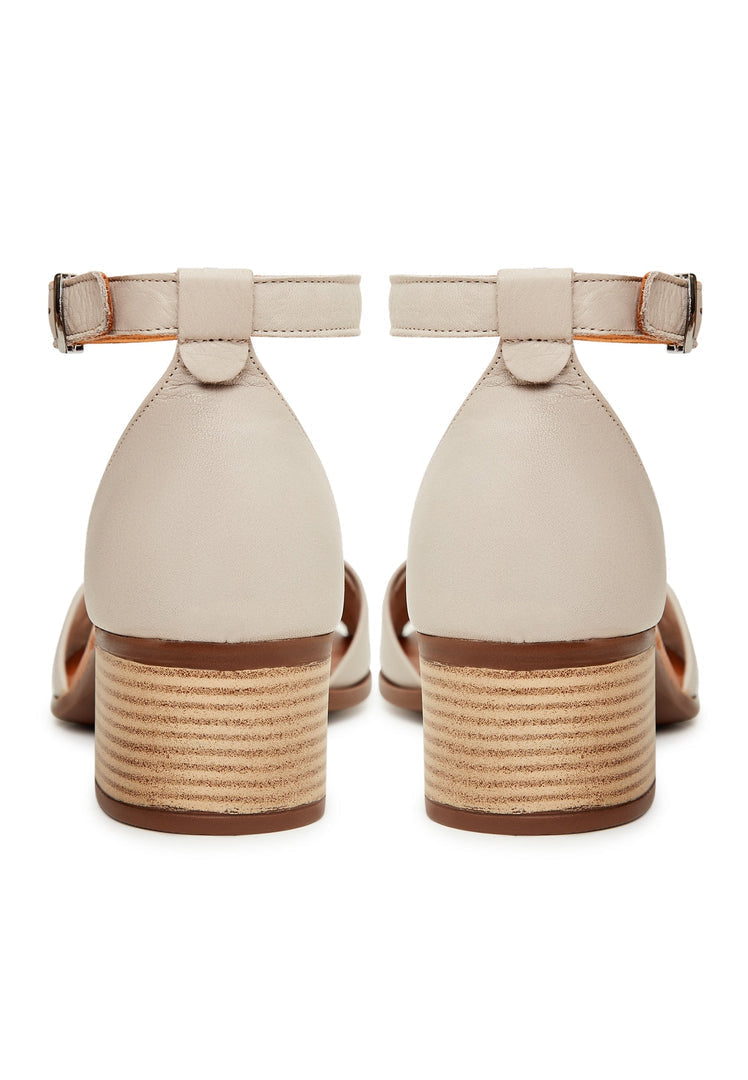 A stylish pair of women's beige block heeled sandals, perfect for any occasion with their neutral color and chunky heel design.