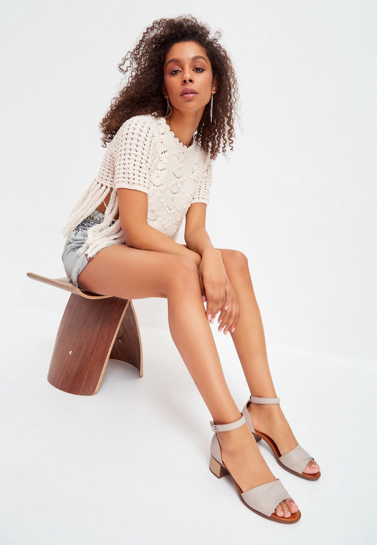 A stylish pair of women's block heeled sandals in a chic beige color, perfect for any outfit.