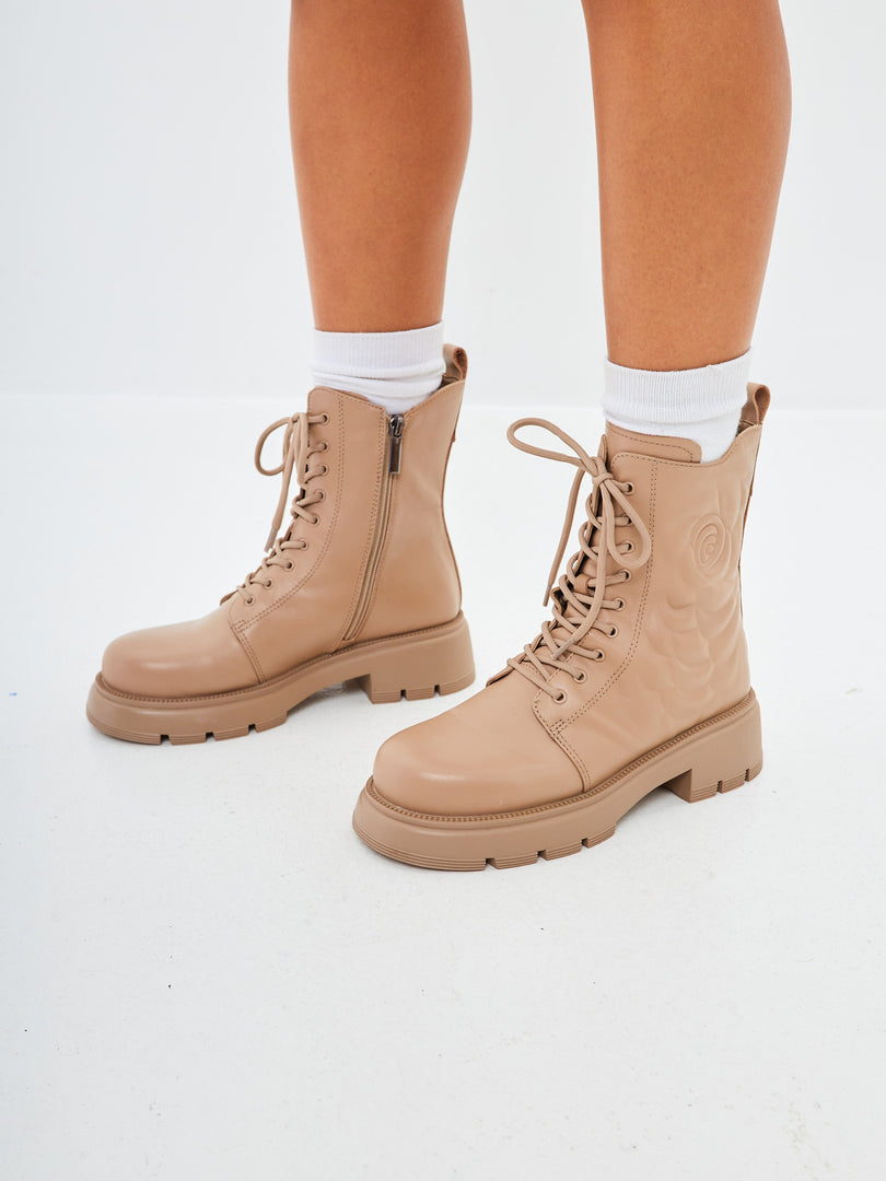 A stylish pair of beige leather platform ankle boots for women, perfect for adding a fashionable flair to your outfit.
