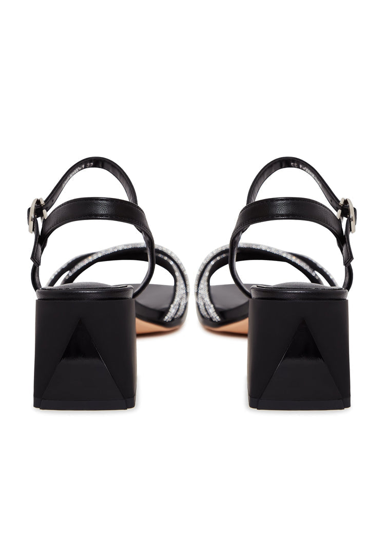 A pair of black leather block heel open toe sandals with high heels, known as the Andrea sandals.