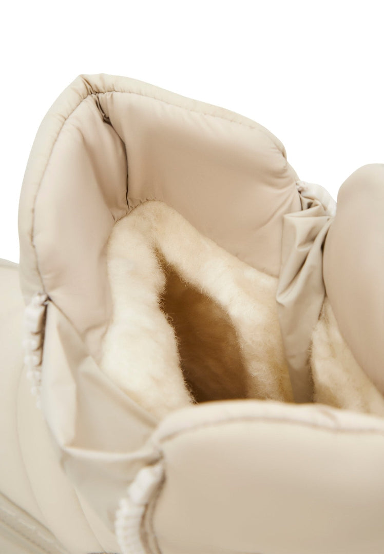 A stylish pair of women's fashion winter boots in beige, featuring a chic platform design.
