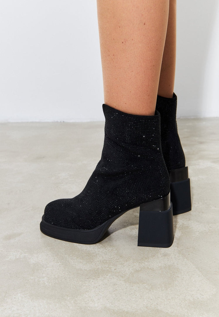A stylish pair of women's black leather ankle boots with a trendy block heel, perfect for adding a fashionable touch to any outfit.