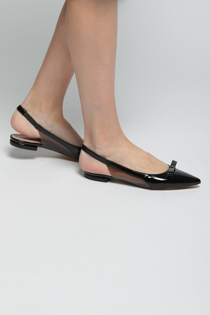 A stylish pair of black slingback shoes with a shimmering bow detail, perfect for a fashionable and elegant look.