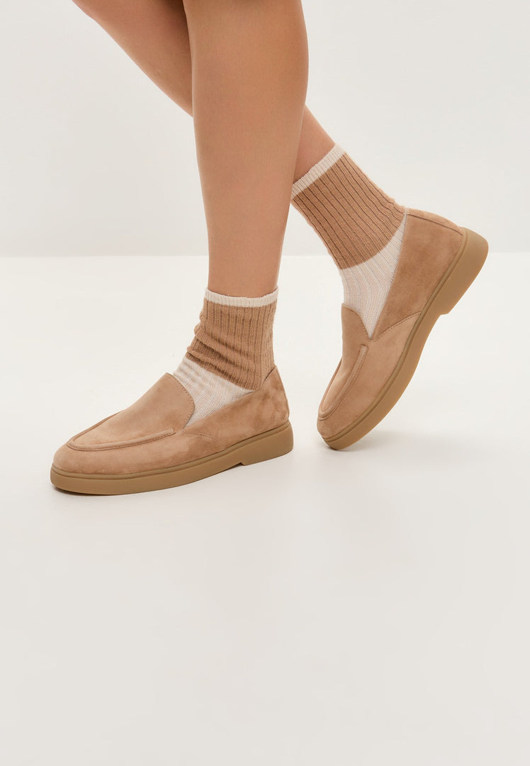 A pair of beige loafers, perfect for urban style with comfort, these trendy and fashionable slip-ons are a must-have footwear choice.