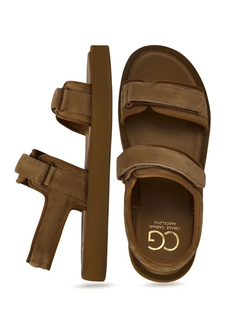 A pair of stylish brown suede women's sandals with velcro fastening for casual comfort.