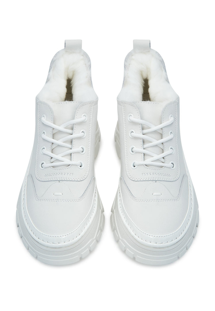 A close-up image showcasing stylish chunky white sneakers with a cozy merino wool lining, perfect for both fashion and comfort.