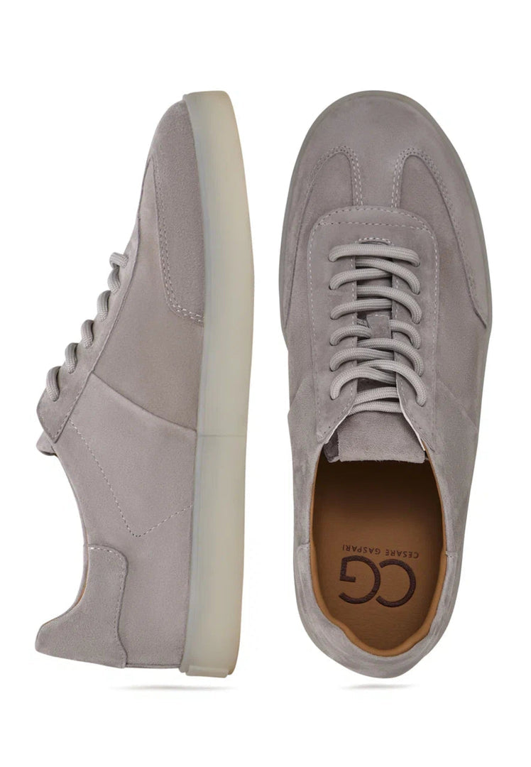 A pair of stylish gray suede low-top sneakers, a classic choice in suede shoes for trendy and versatile footwear.