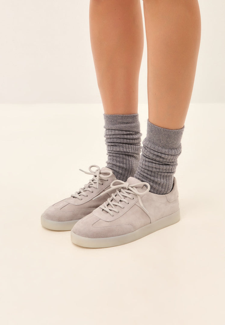 A close-up image of stylish gray suede low-top sneakers, a classic choice of footwear for any casual outfit.