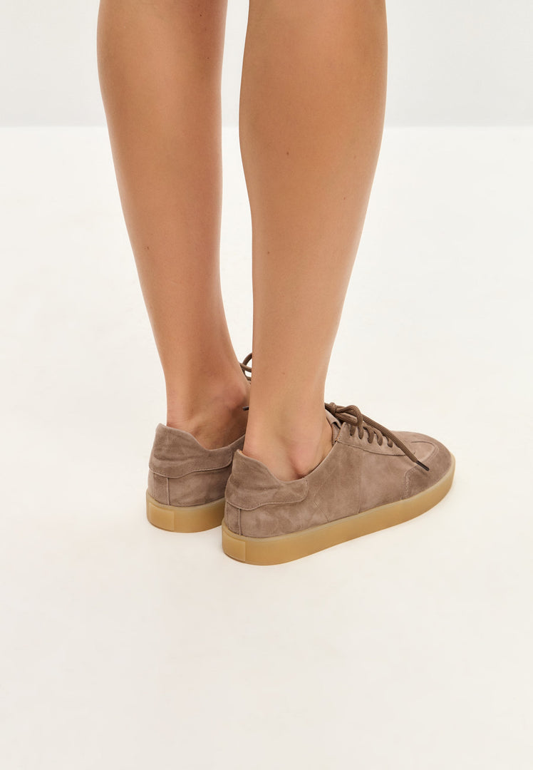 A pair of stylish low-top classic beige suede sneakers, a must-have in footwear fashion.