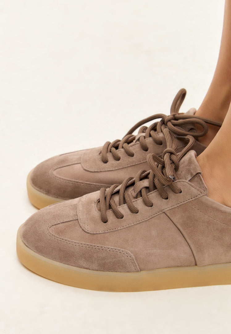 A stylish pair of beige low-top suede sneakers, perfect for classic footwear fashion.