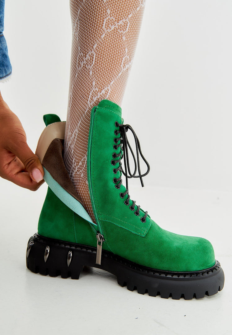 A stylish pair of green lace-up combat boots with a chunky sole, perfect for those who love military-style women's fashion footwear.