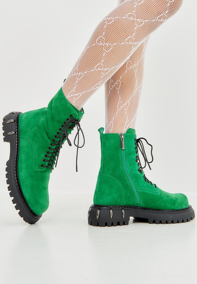 A pair of stylish lace-up combat boots with a chunky sole in trendy green, perfect for a military-style look in women's fashion footwear.