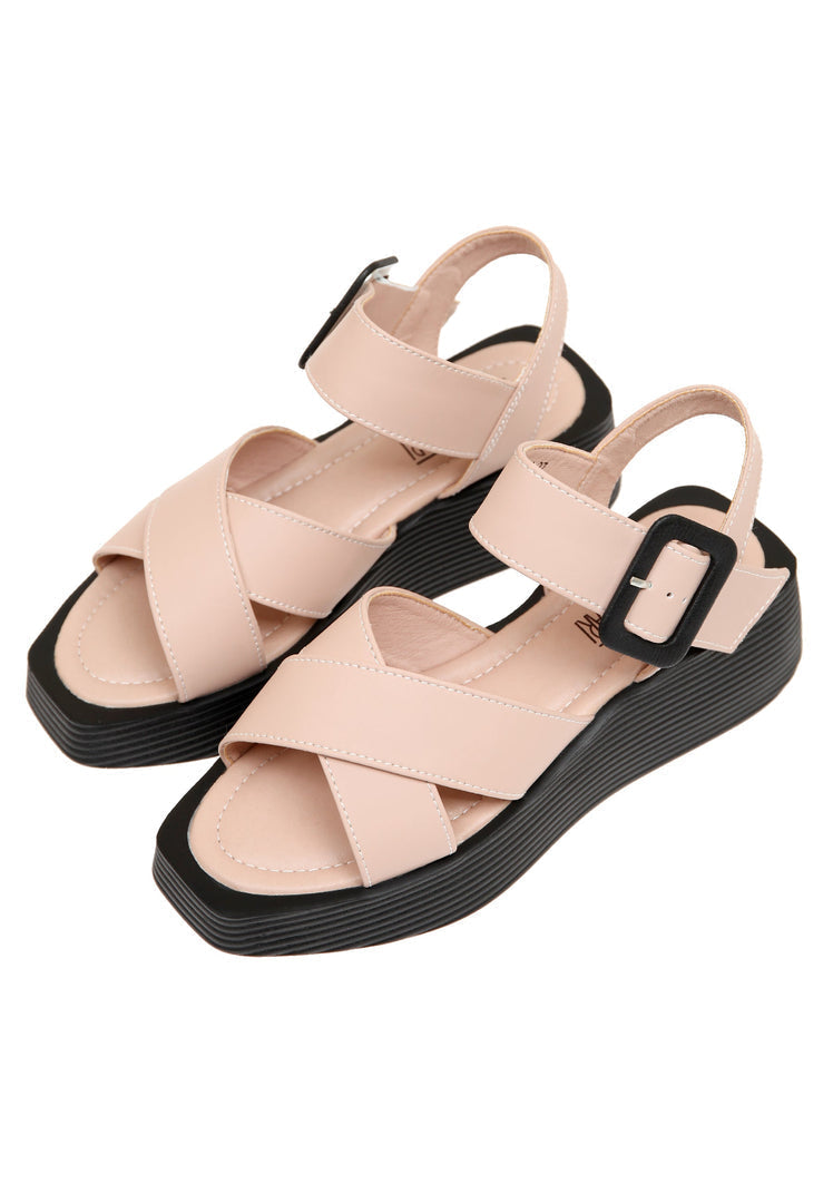 A stylish pair of blush pink women's platform sandals with high heels and strappy details.