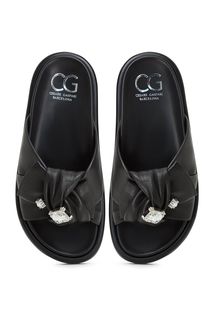 A stylish pair of black platform slippers, also known as Fernanda slippers, for women. These trendy slide sandals are versatile and comfortable footbed sandals.