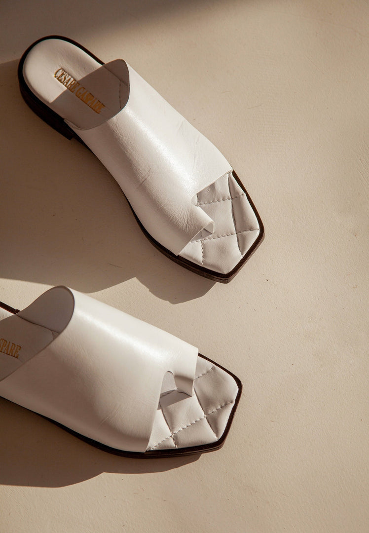 A close-up of flat sole, one toe loop, minimalist sandals that are stylish and comfortable for everyday wear.