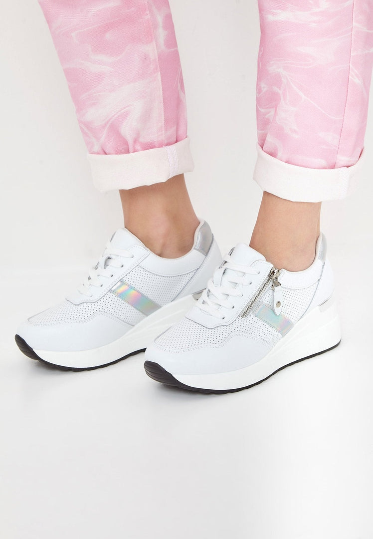 A pair of stylish white leather sneakers on a chic background.