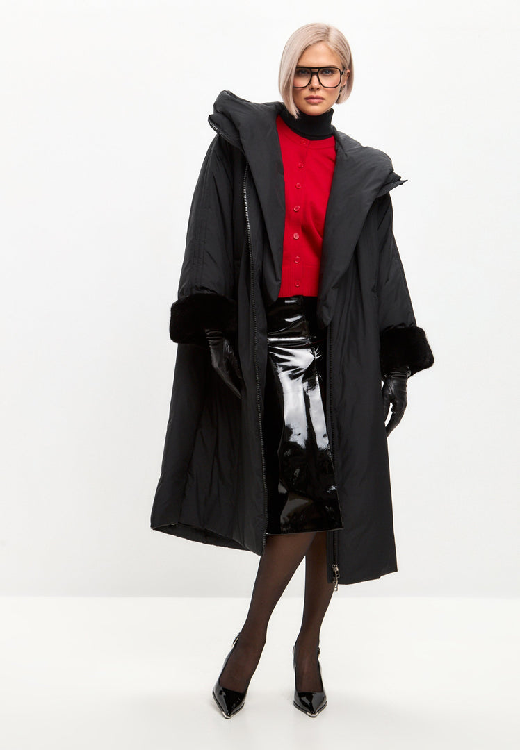 A stylish black oversized puffer coat with a hood and faux fur cuffs - the perfect plus size outerwear for keeping warm and in style this winter in women's fashion.