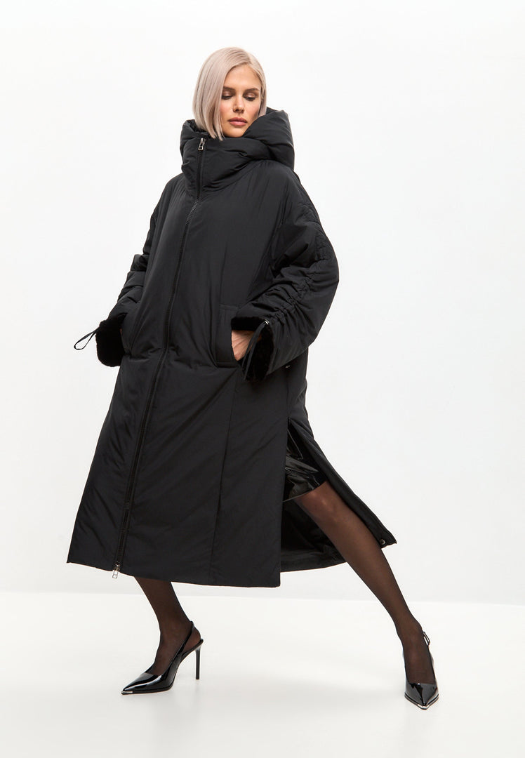 A stylish black oversized puffer coat for plus size women with a hood and faux fur cuffs, the perfect winter fashion statement.