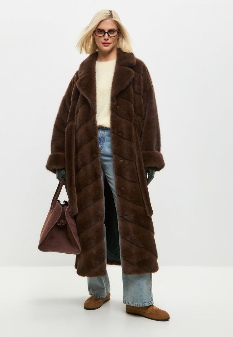 A stylish woman wearing an oversized brown faux fur coat - the perfect trendy statement piece for the winter season in women's outerwear fashion.