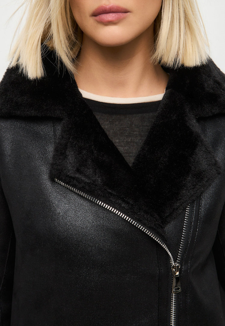 A stylish black shearling coat with a faux shearling jacket design, featuring a reversible long coat style perfect for women's winter outerwear, a trendy choice in shearling clothing.