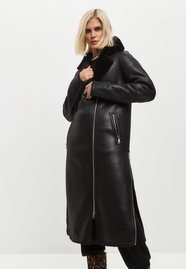 A fashionable black shearling coat, this reversible long coat doubles as a faux shearling jacket, perfect for women's winter outerwear. Stay stylish and cozy in this trendy shearling clothing.