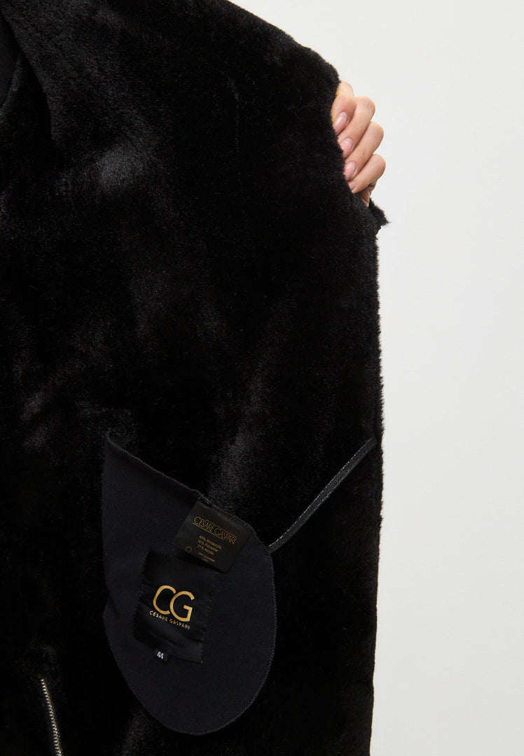 A stylish black shearling coat, reversible long design, perfect for women's winter outerwear fashion. This faux shearling jacket is a trendy addition to your cold-weather wardrobe.