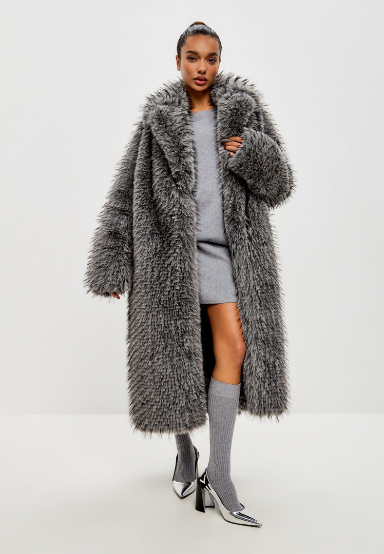 A stylish woman wearing a luxurious black faux fur coat by Natalie, a designer high-end faux fur coat.