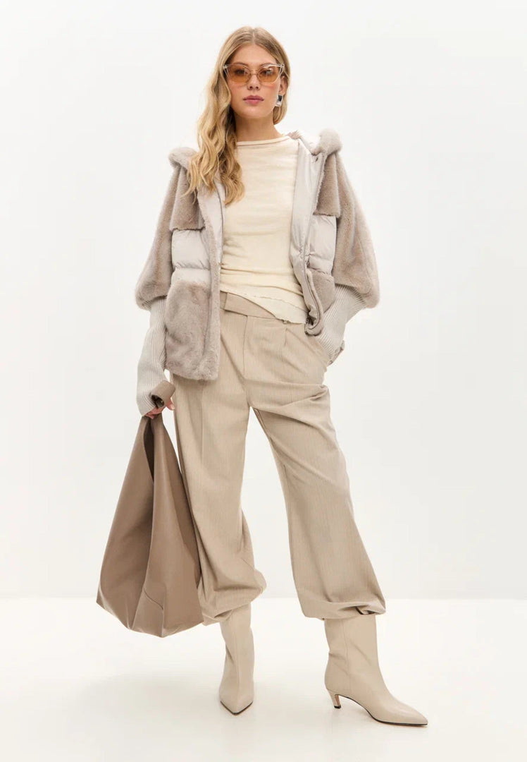 A stylish woman wearing a trendy oversized ivory faux fur jacket, perfect for winter outerwear. Great for plus size women looking for a fashionable faux fur jacket.