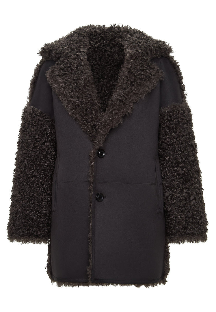 A stylish woman wearing a cozy brown shearling coat known as the Eva coat, a versatile and chic addition to any winter wardrobe.