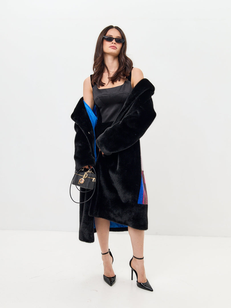 Two stylish women walking arm in arm, one wearing a deluxe black coat and the other a long back print coat - perfect for black coat lovers and deluxe coat lovers.