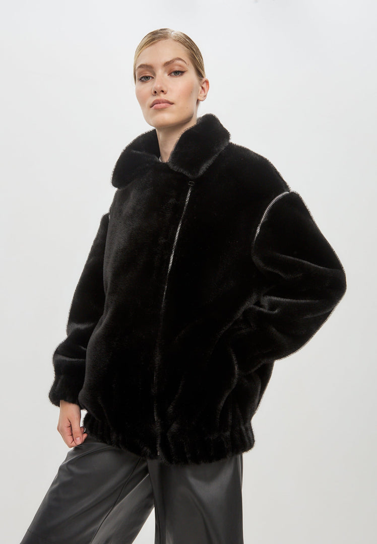 A stylish women's fashion outerwear - a short black faux fur coat in Marilyn style for the winter season.