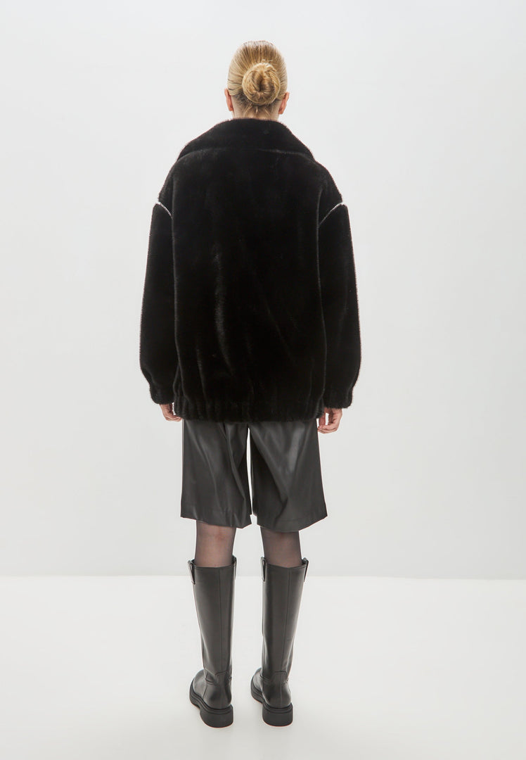 A stylish women's winter coat in Marilyn style, featuring a short black faux fur design - perfect fashion outerwear for the season.