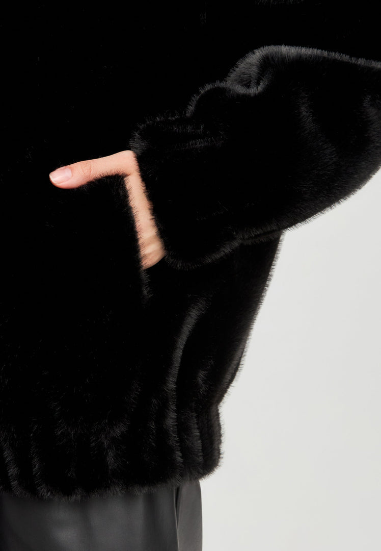 A stylish women's winter faux fur coat in Marilyn style, featuring a short black design perfect for fashion outerwear.