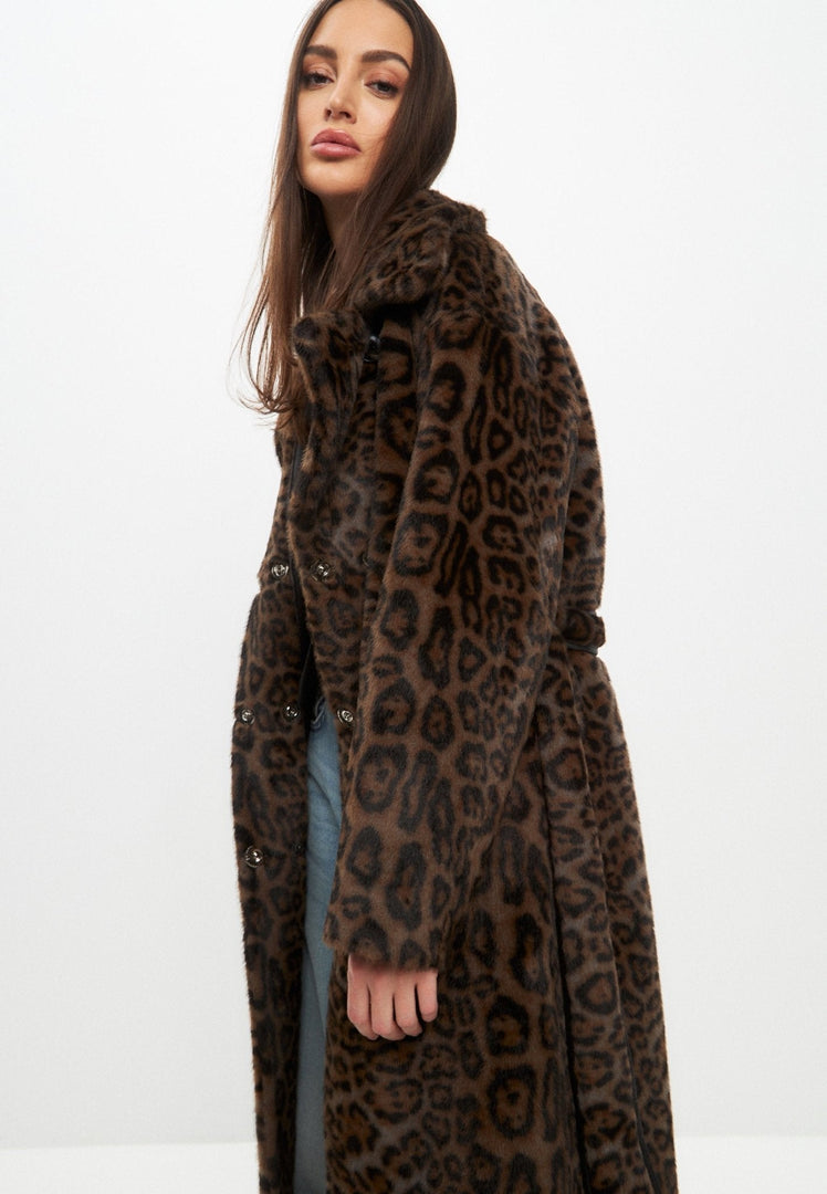 A stylish woman wearing a long winter coat with reversible faux fur lining, perfect for staying warm and fashionable during cold weather.
