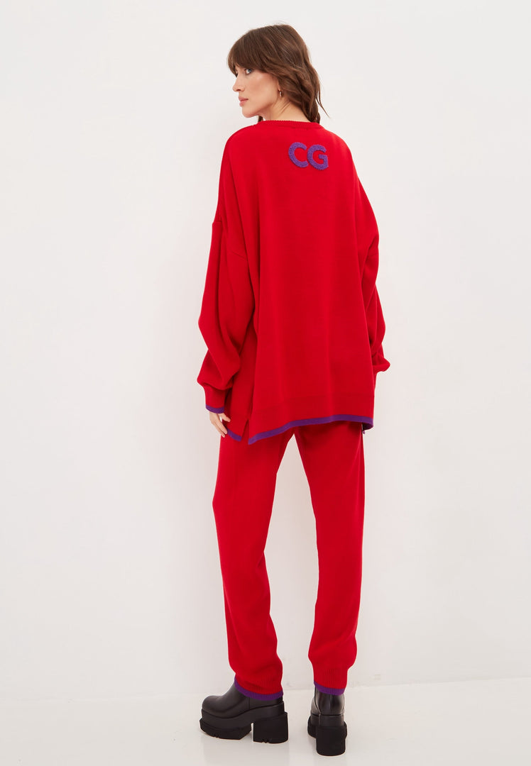 A woman wearing an oversized red lounge set with comfy sweatpants, a perfect plus size activewear look for a stylish and relaxed athleisure outfit.