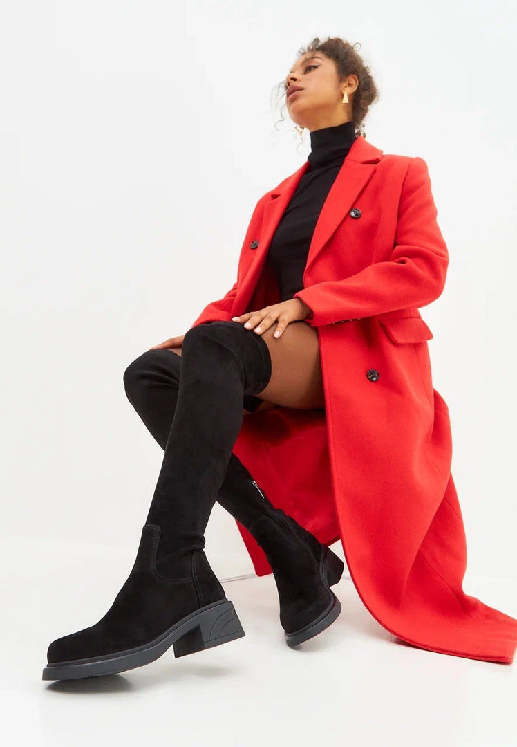A fashionable woman wearing chic over-the-knee suede boots, a stylish choice in women's footwear.