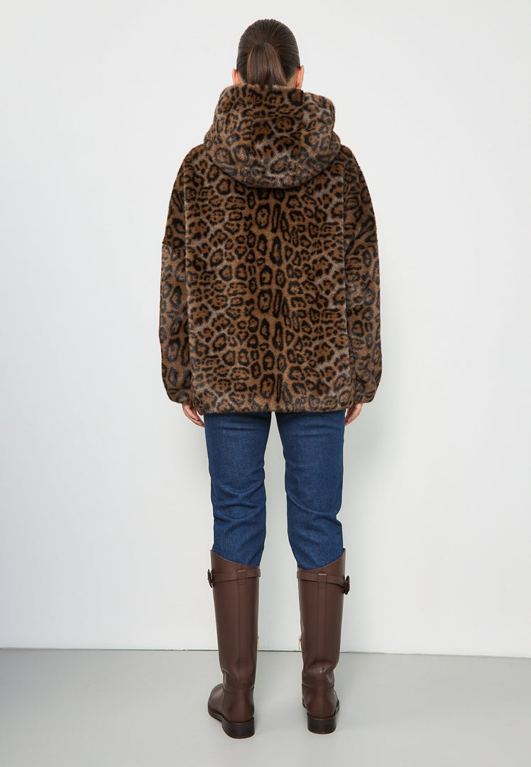 A fashionable woman wearing a stylish faux fur hooded leopard jacket, the Reyna leopard jacket, a trendy women's jacket perfect for the season's faux fur outerwear trend.