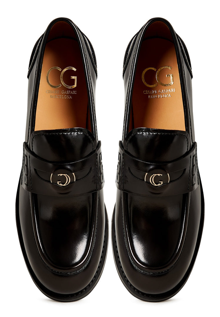A stylish pair of women's black leather loafers with a chunky block heel, known as Dinara black shoes.