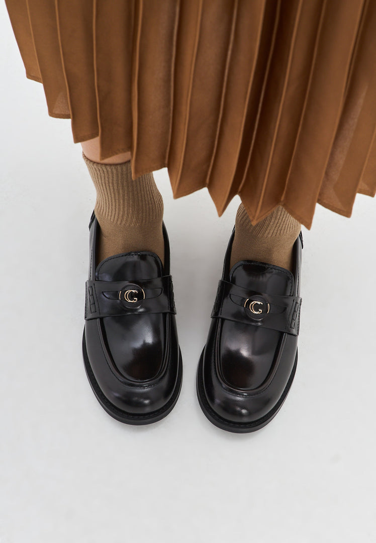 A stylish pair of black leather block heeled loafers, known as Dinara black shoes, for women featuring a chunky heel design.